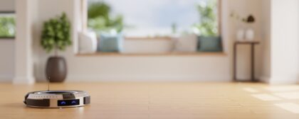 Robot vacuum on a wooden floor with a home lounge in the background